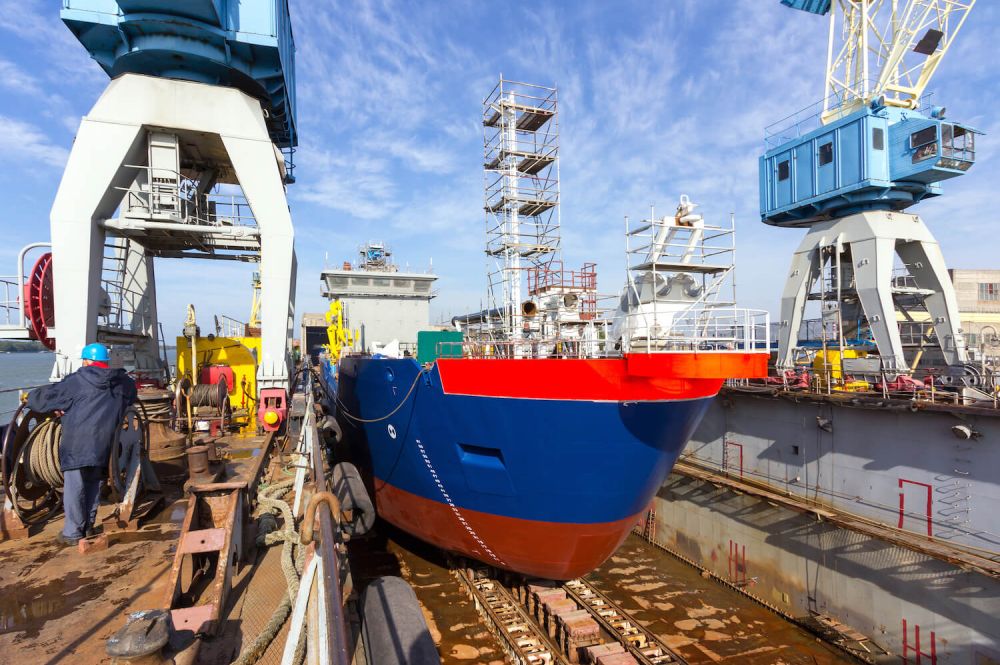 A cargo ship being built in a dock at a shipyard